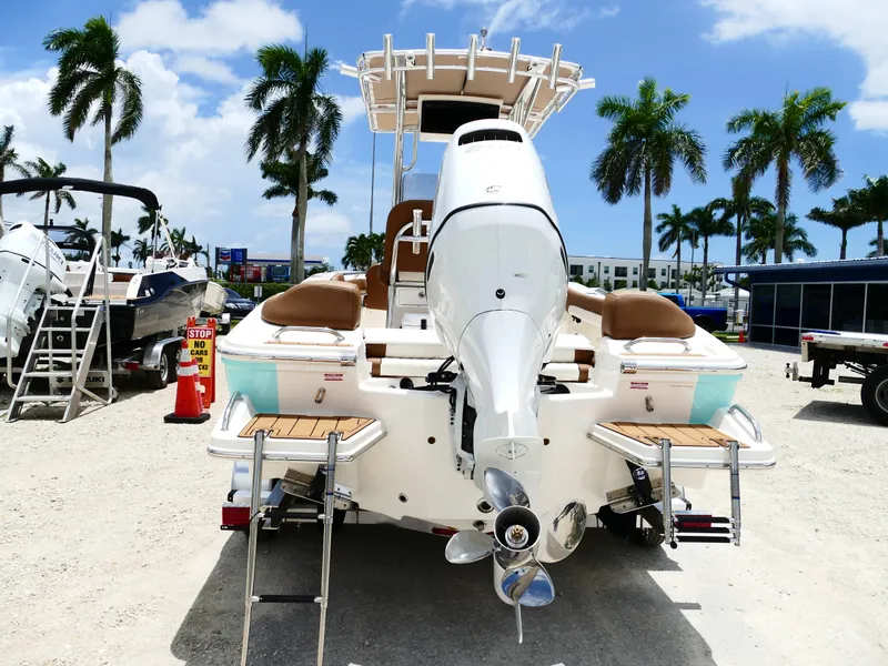 Slide: The Image of 2026 Pioneer 202 Islander boat with outboard motor, parked outdoors under palm trees. - 8