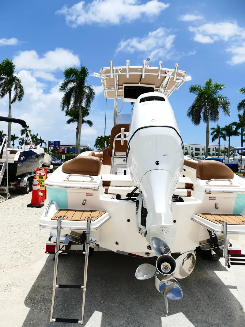Slide: The Image of 2026 Pioneer 202 Islander boat with outboard motor, docked under sunny skies and palm trees. - 9