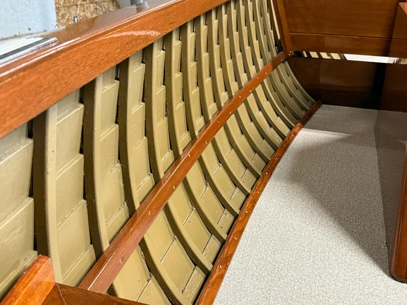 Slide: The Image of 1955 Lyman 18 Inboard boat interior with wooden ribs and beige flooring. - 12