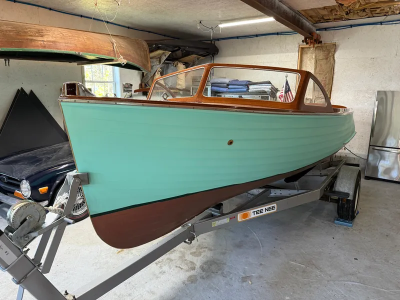 Slide: The Image of 1955 Lyman 18 Inboard boat in garage, teal hull, wooden trim, on trailer. - 17