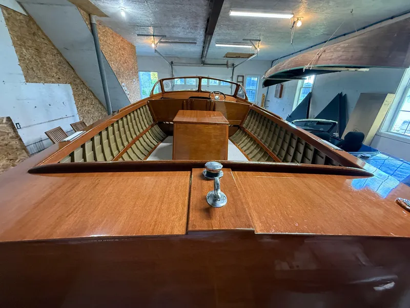 Slide: The Image of 1955 Lyman 18 Inboard boat with polished wood interior in a garage setting. - 5