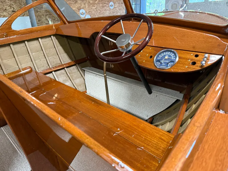 Slide: The Image of 1955 Lyman 18 Inboard boat interior with wooden dashboard and steering wheel. - 6