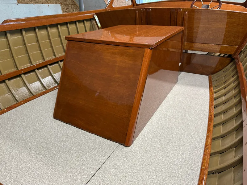 Slide: The Image of 1955 Lyman 18 Inboard boat interior with polished wood and beige seating. - 9