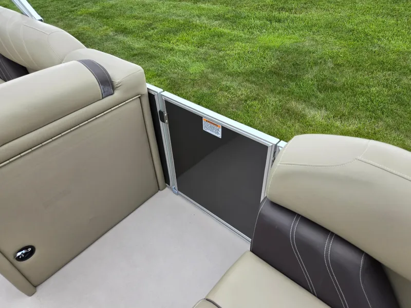 Slide: The Image of 2022 Sylvan Mirage Fish 822 Party Fish boat interior with beige seating and green grass background. - 12