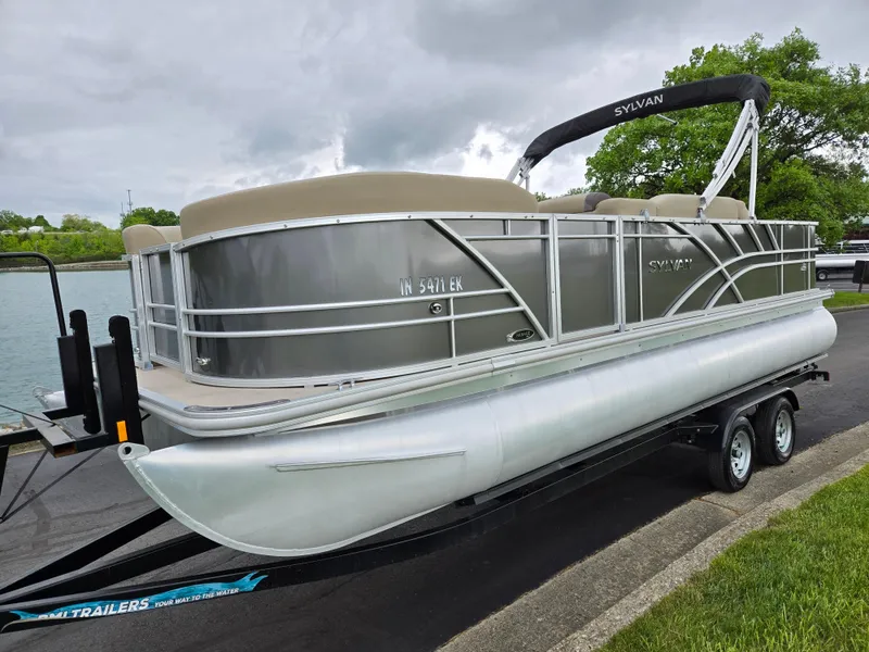 Slide: The Image of 2022 Sylvan Mirage Fish 822 Party Fish pontoon boat on trailer by a lake. - 8