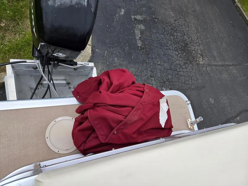 Slide: The Image of Red jacket on Harris FloteBote 200 Cruiser CX, 2010 model, near outboard motor. - 17