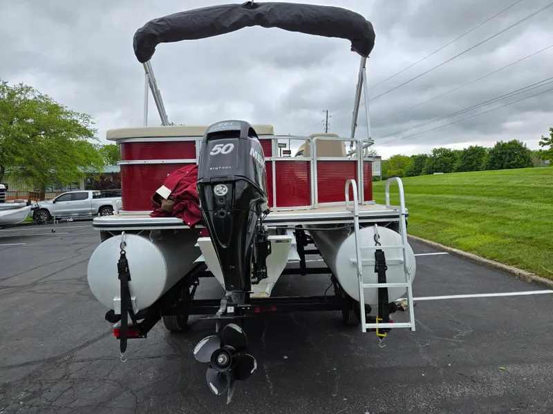 Slide: The Image of 2010 Harris FloteBote 200 Cruiser CX pontoon boat with outboard motor in parking lot. - 2
