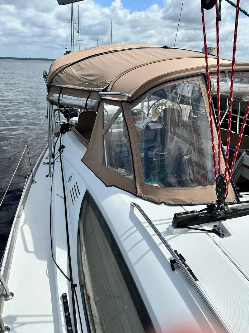 Slide: The Image of 2011 Jeanneau Sun Odyssey 45 DS sailboat with beige canopy on calm water. - 14