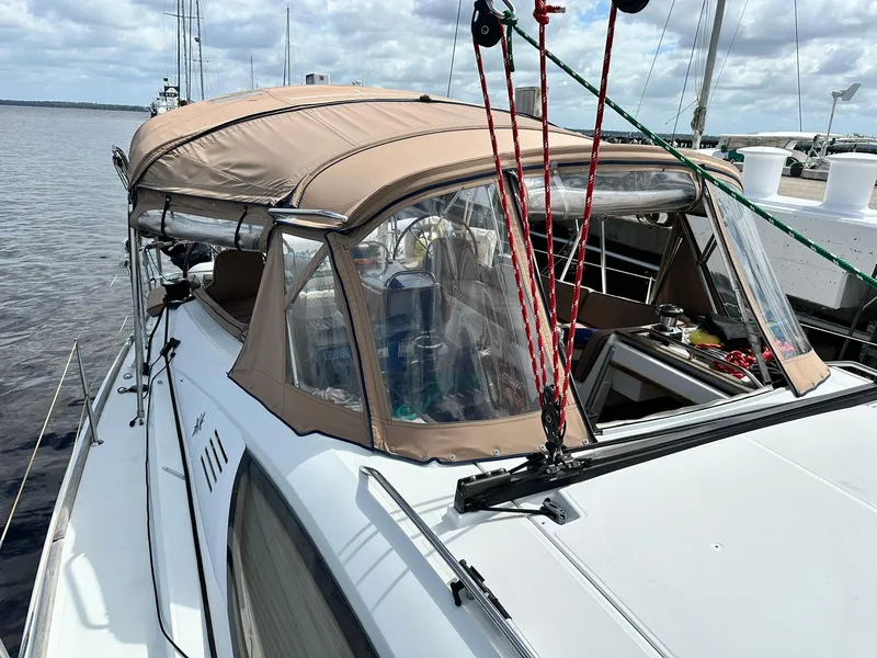 Slide: The Image of 2011 Jeanneau Sun Odyssey 45 DS sailboat with beige canopy docked by the water. - 15