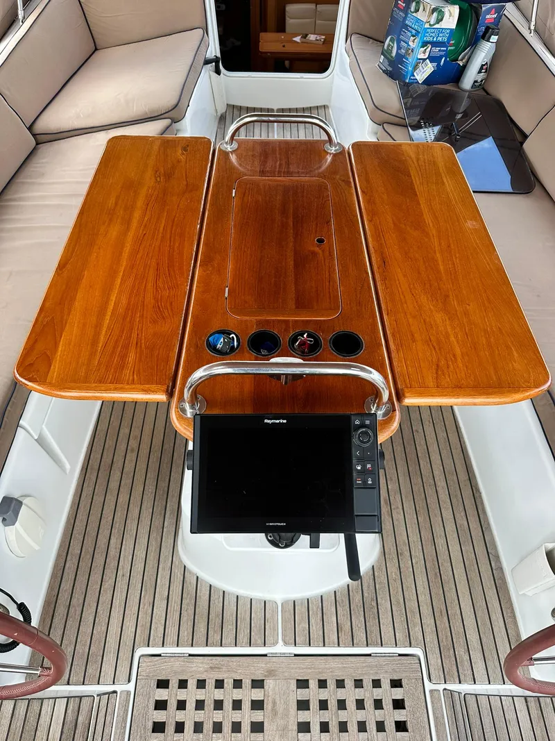Slide: The Image of Cockpit of 2011 Jeanneau Sun Odyssey 45 DS with wooden table and navigation equipment. - 33