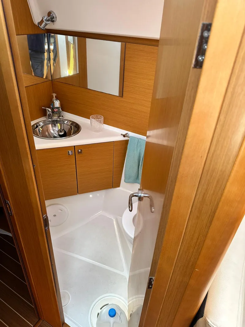 Slide: The Image of Bathroom interior of 2011 Jeanneau Sun Odyssey 45 DS yacht, featuring sink and wooden cabinetry. - 47