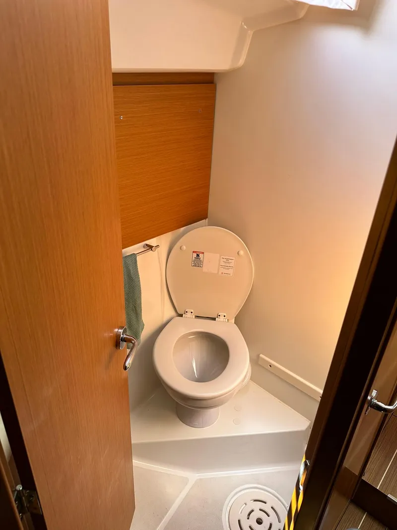 Slide: The Image of 2011 Jeanneau Sun Odyssey 45 DS yacht bathroom with toilet and wooden door. - 50