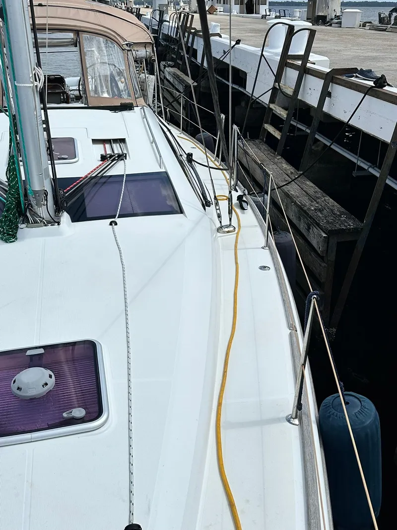 Slide: The Image of 2011 Jeanneau Sun Odyssey 45 DS sailboat docked, showcasing deck and mooring lines. - 6