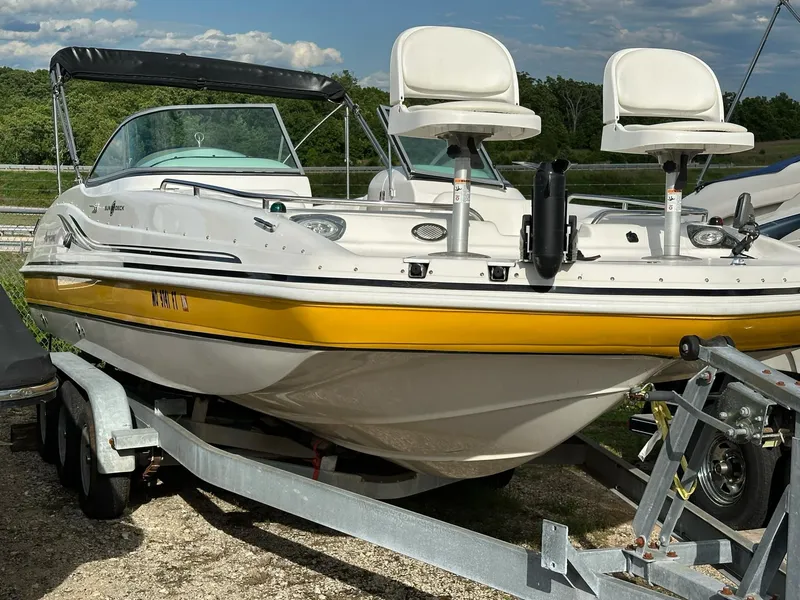 Slide: The Image of 2012 Hurricane SunDeck 237 OB boat on trailer, featuring yellow accents and dual seating. - 12
