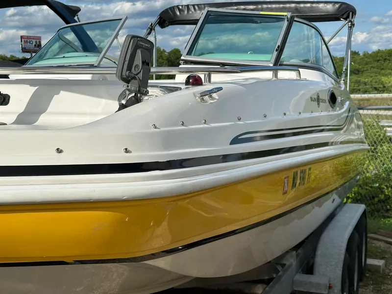 Slide: The Image of 2012 Hurricane SunDeck 237 OB boat with yellow hull on a trailer. - 14