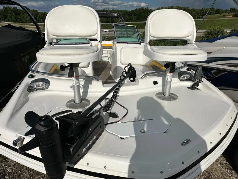 Slide: The Image of 2012 Hurricane SunDeck 237 OB boat with dual white seats and fishing equipment. - 16