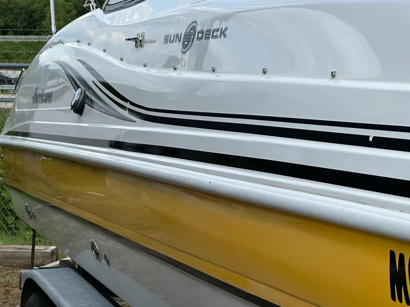 Slide: The Image of 2012 Hurricane SunDeck 237 OB boat with sleek design and yellow hull. - 21