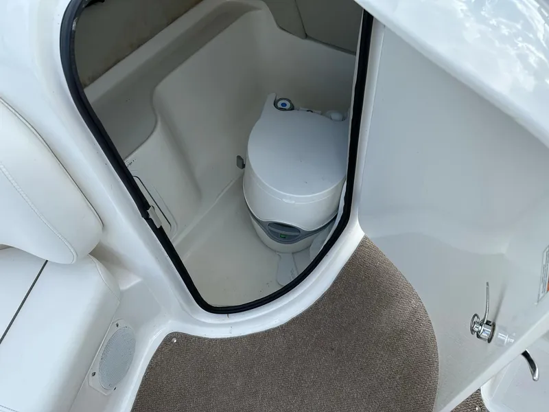 Slide: The Image of 2012 Hurricane SunDeck 237 OB boat interior with compact marine toilet. - 23