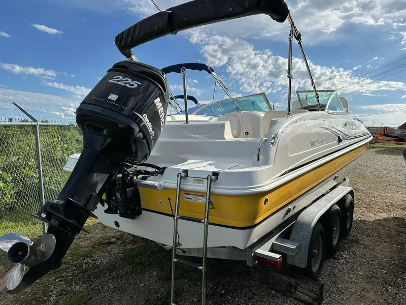 Slide: The Image of 2012 Hurricane SunDeck 237 OB boat with Mercury 225 engine on trailer, under blue sky. - 24