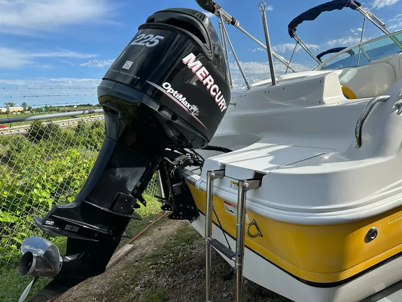 Slide: The Image of 2012 Hurricane SunDeck 237 OB boat with Mercury 225 outboard motor, docked near greenery. - 3