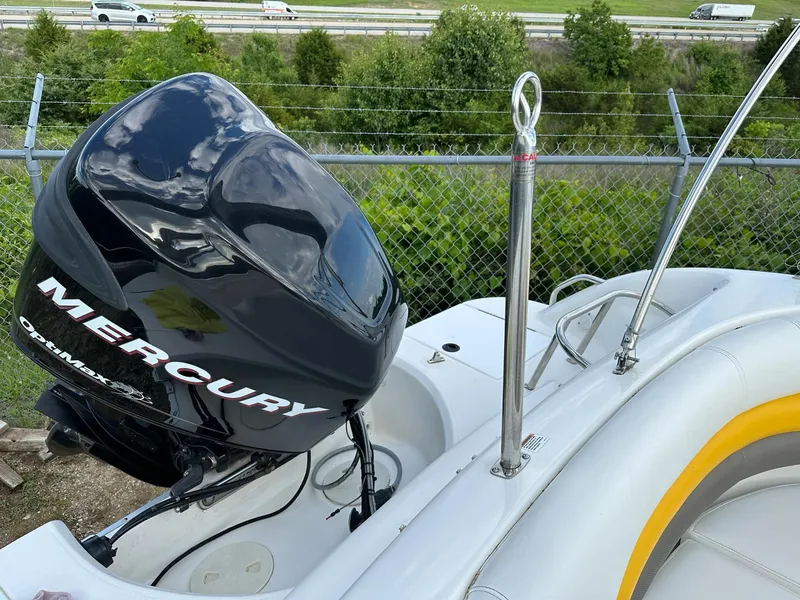 Slide: The Image of 2012 Hurricane SunDeck 237 OB with Mercury outboard motor, parked near a highway. - 6