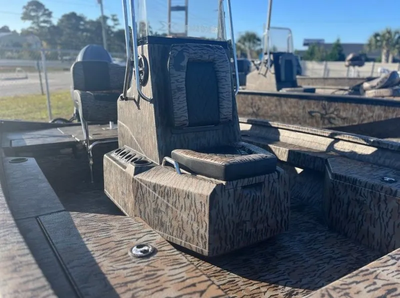 Slide: The Image of 2024 Xpress H20B boat interior with camouflage design, featuring console and seating. - 4