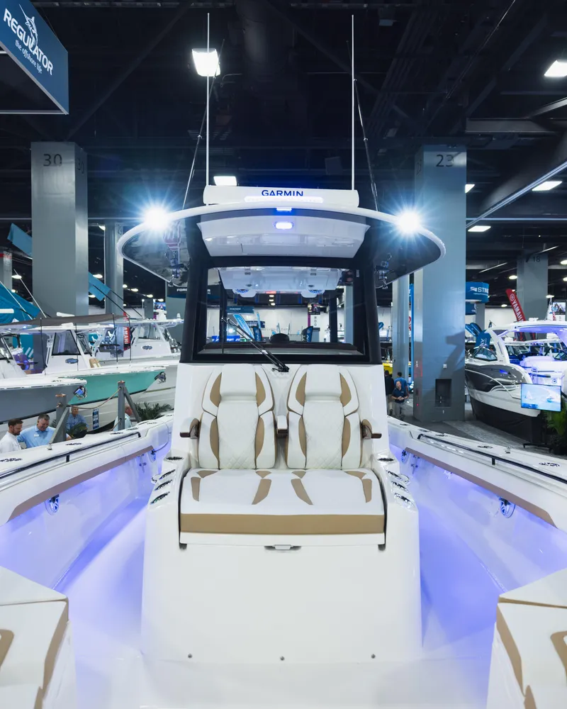 Slide: The Image of 2026 Regulator 35 boat displayed at an indoor boat show, featuring modern design and lighting. - 5