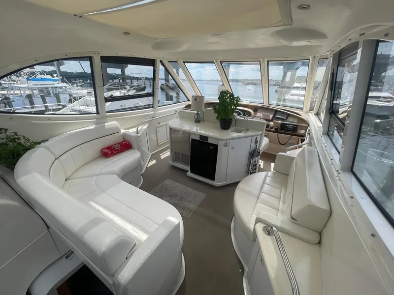 Slide: The Image of Interior of 2000 Carver 506 Motor Yacht with white seating and panoramic windows. - 26