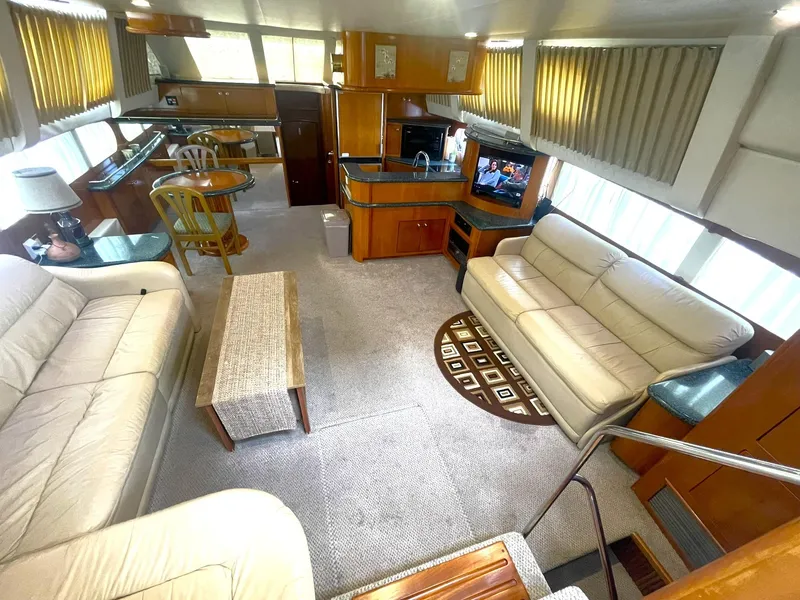 Slide: The Image of Luxurious interior of 2000 Carver 506 Motor Yacht with sofas, dining area, and entertainment center. - 6
