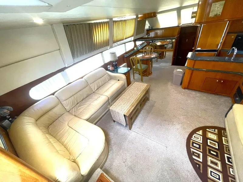 Slide: The Image of Interior of 2000 Carver 506 Motor Yacht with beige seating and wooden furnishings. - 8