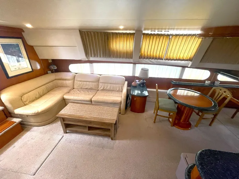Slide: The Image of Interior of 2000 Carver 506 Motor Yacht with beige seating and dining area. - 9