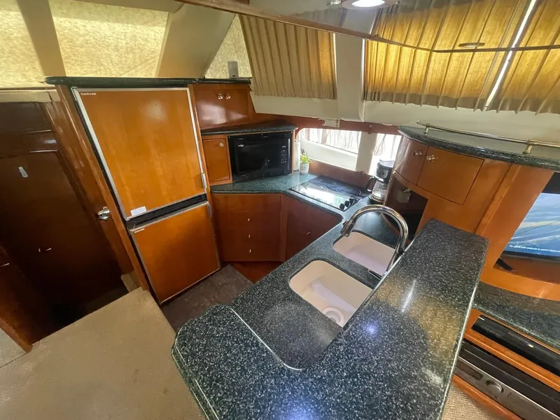 Slide: The Image of Interior of 2000 Carver 506 Motor Yacht kitchen with wood cabinetry and granite countertops. - 17