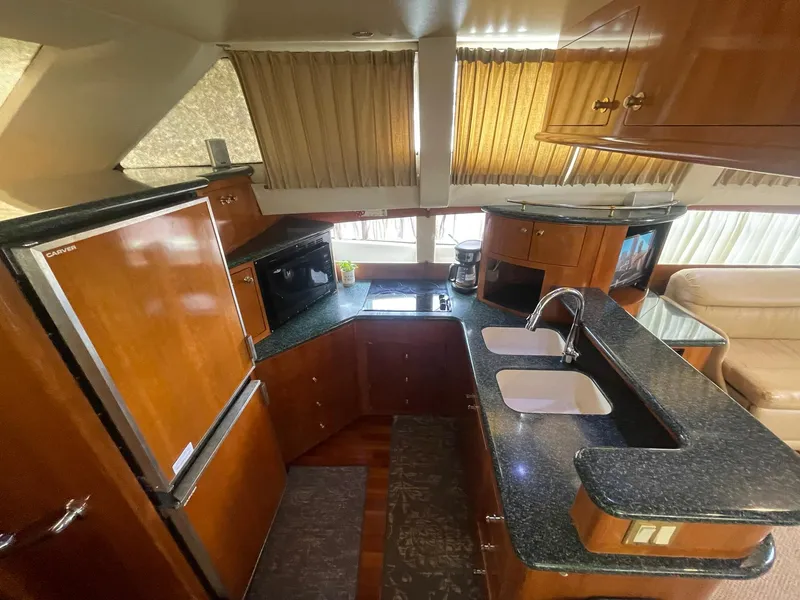 Slide: The Image of Interior of 2000 Carver 506 Motor Yacht kitchen with wood cabinetry and modern appliances. - 19