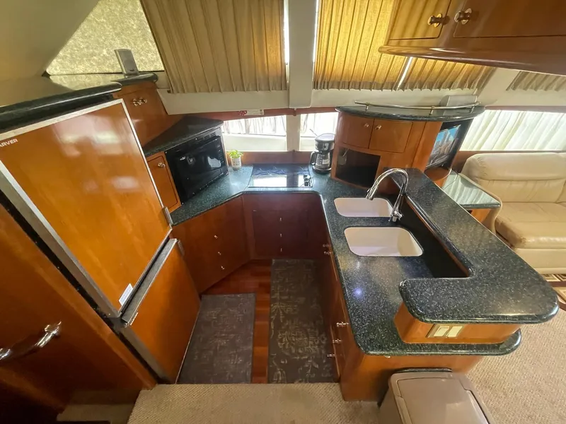 Slide: The Image of Interior of 2000 Carver 506 Motor Yacht kitchen with wood cabinetry and dual sinks. - 20