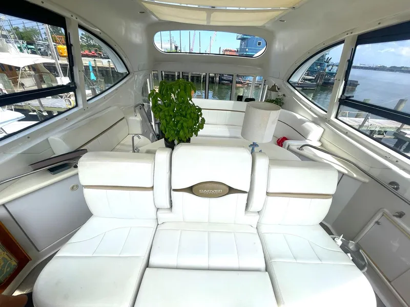Slide: The Image of Interior of 2000 Carver 506 Motor Yacht with white seating and potted plants. - 27