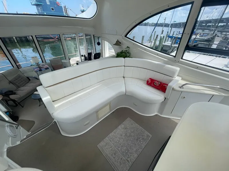 Slide: The Image of Luxurious interior of 2000 Carver 506 Motor Yacht with white seating and waterfront view. - 30