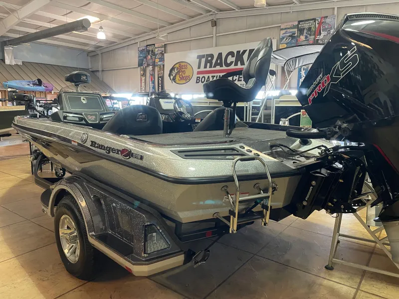 Slide: The Image of 2025 Ranger Z518 boat displayed indoors with motor and trailer. - 3