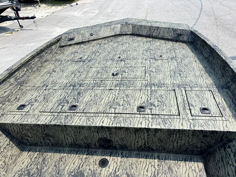 Slide: The Image of 2025 Tracker Grizzly 2072 CC boat deck with camouflage pattern, featuring storage compartments. - 12