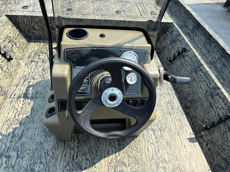 Slide: The Image of 2025 Tracker Grizzly 2072 CC boat console with steering wheel and gauges. - 17