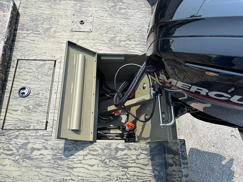 Slide: The Image of 2025 Tracker Grizzly 2072 CC boat with open storage compartment and visible engine components. - 20