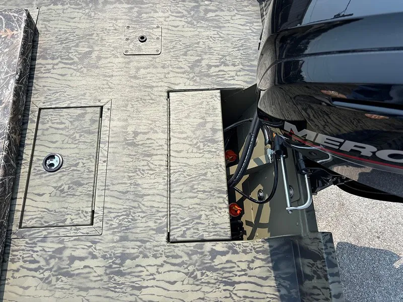 Slide: The Image of 2025 Tracker Grizzly 2072 CC boat deck with camo pattern and Mercury outboard motor. - 21