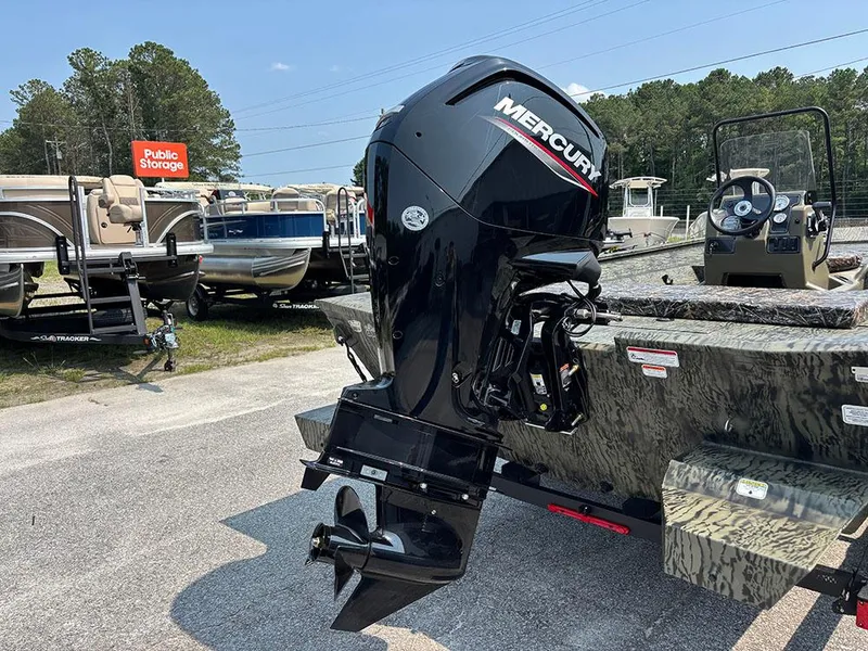 Slide: The Image of 2025 Tracker Grizzly 2072 CC boat with Mercury outboard motor in a storage lot. - 22