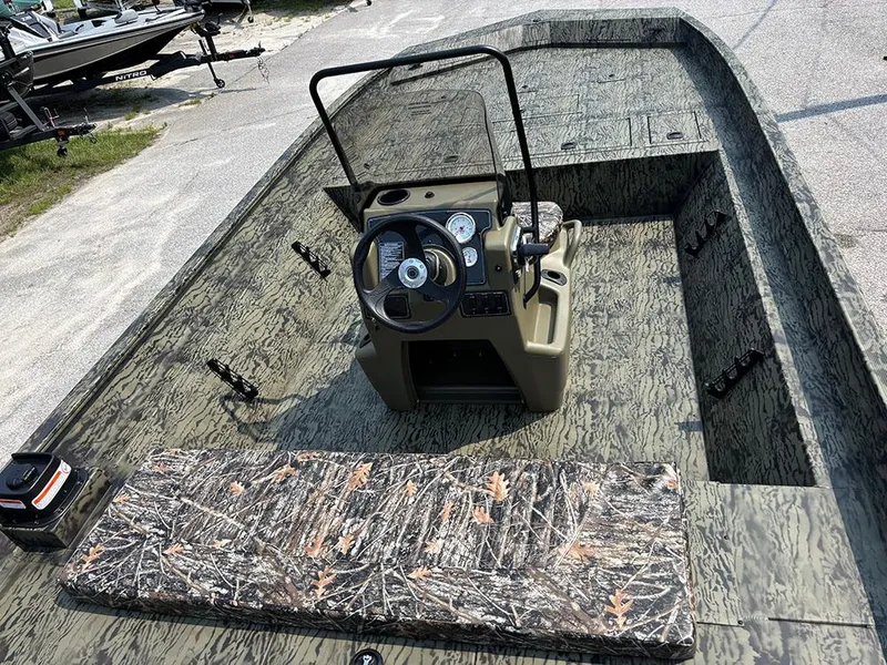 Slide: The Image of 2025 Tracker Grizzly 2072 CC boat interior with camo seating and steering console. - 9
