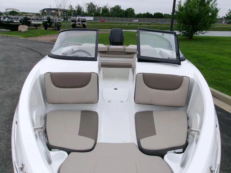 Slide: The Image of 2025 Tahoe 200 S boat interior with beige seating, open windshield, and cup holders. - 3