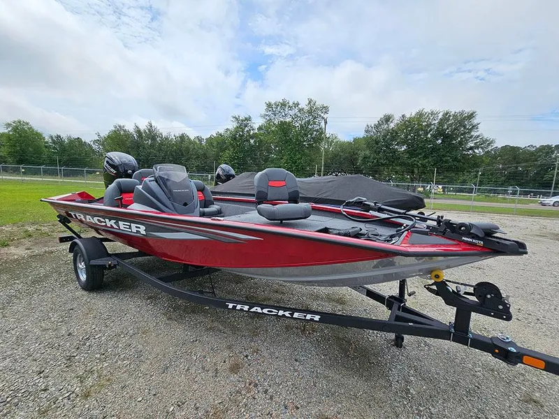 The Image of 2025 Tracker Pro Team 175 boat on trailer, red and black design, parked outdoors. - 1