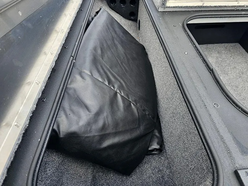 Slide: The Image of Storage compartment of 2025 Tracker Pro Team 175 boat with black cover. - 16