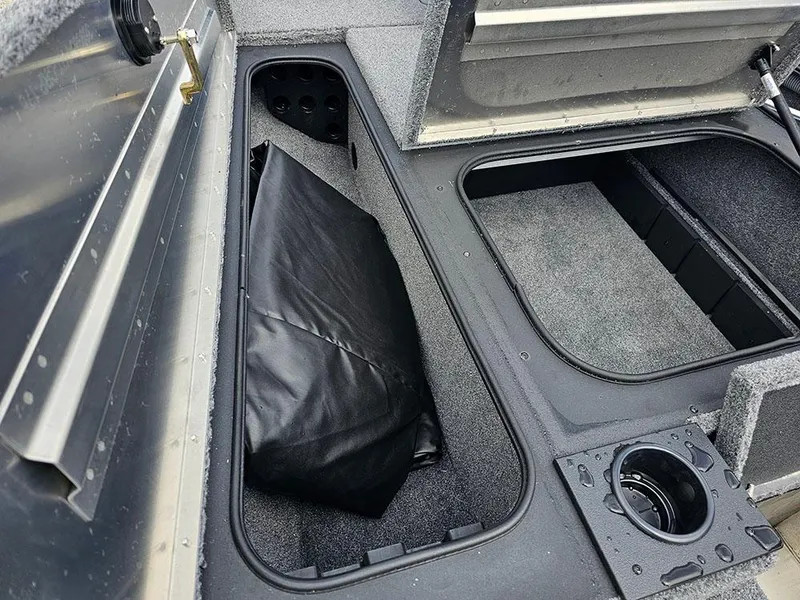 Slide: The Image of 2025 Tracker Pro Team 175 boat storage compartments with black cover and cup holder. - 17