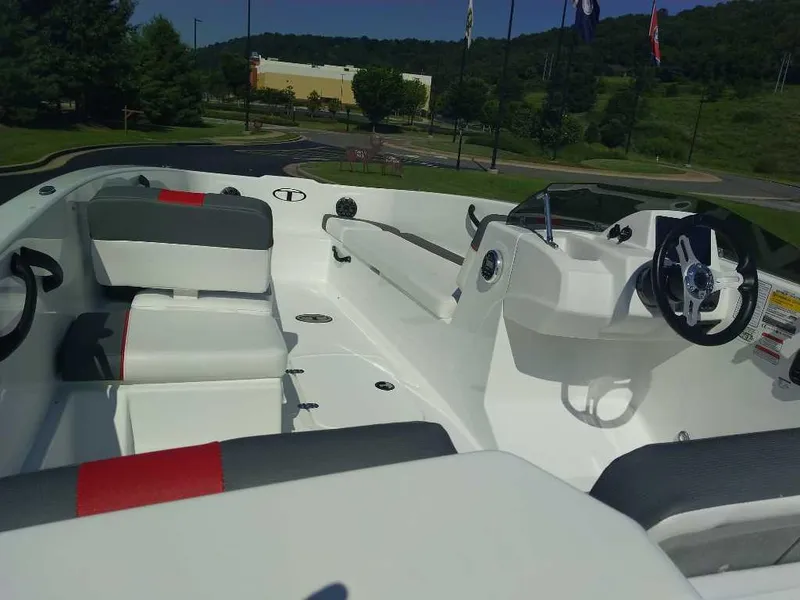 Slide: The Image of 2025 Tahoe T18 boat interior with modern seating and steering wheel, set in a scenic outdoor location. - 4