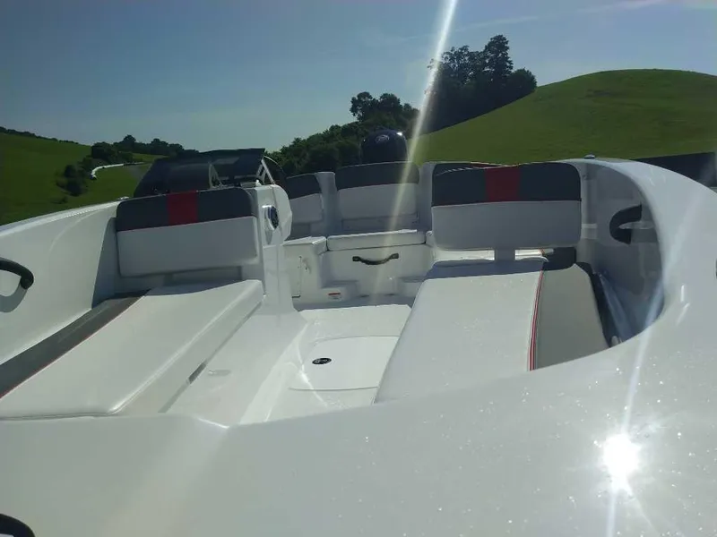 Slide: The Image of 2025 Tahoe T18 boat interior with seating, under sunny skies and green hills. - 5