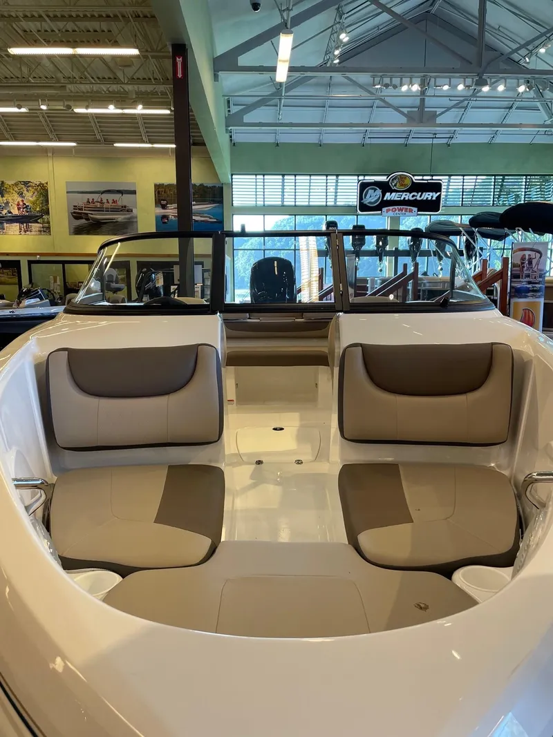 Slide: The Image of 2025 Tahoe 200 S boat interior with beige seating in a showroom. - 2